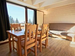 una sala da pranzo con tavolo, sedie e un letto di Studio cabine avec parking couvert à Chamrousse - FR-1-340-122 a Chamrousse