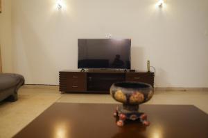 una sala de estar con TV y un jarrón sobre una mesa en 3 Bedroom home in DHA, en Lahore