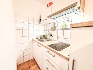a small kitchen with white cabinets and a sink at Apartment Gottwald by Interhome in Starigrad-Paklenica +28 photos