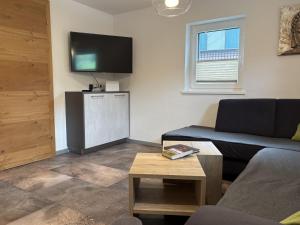 a living room with a couch and a flat screen tv at Holiday Home Machreich by Interhome in Bruck an der Großglocknerstraße