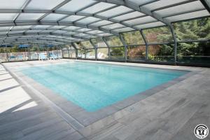 a large swimming pool with a glass roof at Chambres d'hôtes de montcausson in Revel
