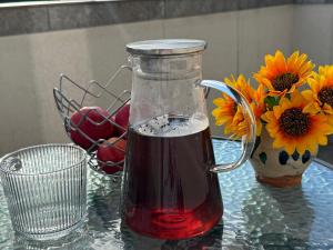 a glass jar filled with red liquid next to a vase with flowers at Cabana Sun Valley in Moara de Pădure