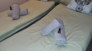 2 lits avec serviettes et animaux rembourrés dans l'établissement Ferienwohnung Osser Woid, à Lohberg