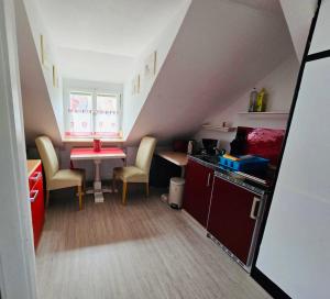 a small kitchen with a table and chairs in a attic at Apartment Altstadt 50m vom Bodensee in Meersburg +3 photos