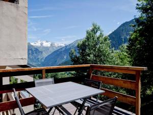 a table and chairs on a balcony with mountains at Appartement rénové 3 pièces, 150m remontées mécaniques et centre Courchevel 1550 - FR-1-514-42 in Courchevel +5 photos