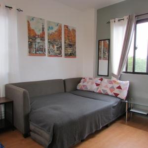 a living room with a couch and some paintings on the wall at Casa Devino - Spacious 76 SQM 2BR Loft Retreat in Tagaytay - Pool - Free WIFI NETFLIX PARKING PET Stay - located on 3rd Floor in Tagaytay +53 photos
