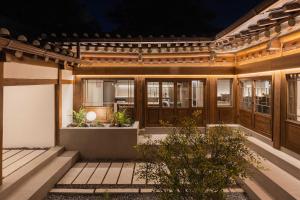 a house with wooden doors and a courtyard at Luxury Hanok Retreat Dohyun in Seoul