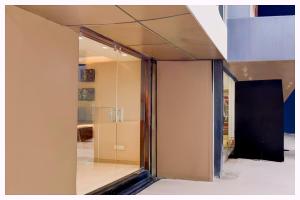 a glass pivot door in a room with a kitchen at Hotel B-Paradise - Near Kashi Vishwanath Temple - Fully Air Conditioned And Spacious Rooms With #Wi-fi - Restaurant And Free Parking Available & Best Hotel In Varanasi - Book Now in Rāmnagar