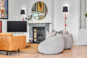 ein Wohnzimmer mit Sofa und Fernseher in der Unterkunft The BeBe on Gover - Heritage Gem in North Adelaide in North Adelaide