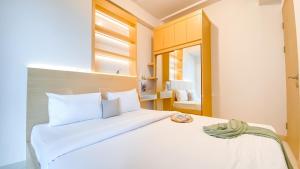 una camera da letto con un grande letto bianco con una finestra di PIK2 Tokyo Riverside Apartment Studio a Muara Altre 13 foto