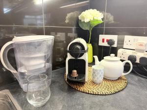 a kitchen counter with a blender and cups on a counter at London Westfield Bedroom in London