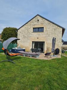 a house with a yard with a patio and a building at Maison en pierre, proche du Futuroscope in Scorbé-Clairvaux