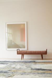 eine Bank an einer Wand mit einem Spiegel in der Unterkunft Stadtflucht Homes in Berlin