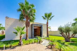 马拉喀什Villa Hawai, ss vis à vis avec espace de sport , piscine Chauffée的一栋门前有棕榈树的房子