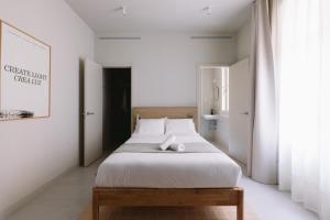 a bedroom with a large white bed with a wooden frame at Outsite Barcelona in Barcelona
