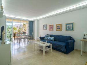 a living room with a blue couch and a table at Miramar By CanariasGetaway in Mogán +50 photos
