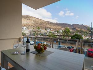 a table with a bowl of fruit and wine glasses at Miramar By CanariasGetaway in Mogán