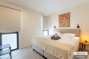 a bedroom with a bed and a painting on the wall at Appartement The Wharf 5C Willemstad in Willemstad +11 photos