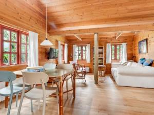 a dining room and living room with wooden ceilings at Holiday Home Henke - 100m from the sea by Interhome in Læsø +11 photos