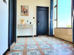 a hallway with a black door and a tile floor at DALI FLOWER&CAT VILLa in Dali