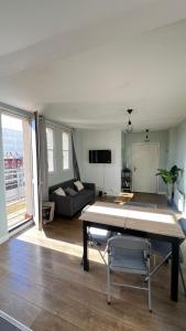 a living room with a table and a couch at Superbe appartement en Hauteur style NEW Yorkais - Proche Métro Paris Idéal pour couple et professionnels Toutes commodités à proximité in Saint-Ouen