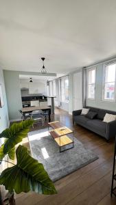 a living room with a couch and a coffee table at Superbe appartement en Hauteur style NEW Yorkais - Proche Métro Paris Idéal pour couple et professionnels Toutes commodités à proximité in Saint-Ouen