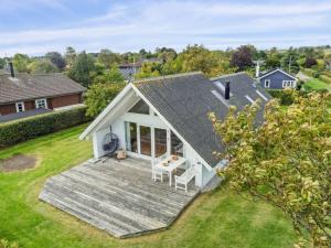 ein Haus mit einer Holzterrasse im Hof in der Unterkunft Holiday Home Jolanta - 20m from the sea by Interhome in Malling