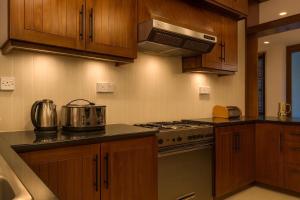 a kitchen with wooden cabinets and a stove top oven at Unique Towers Luxury Boutique Suites in Colombo +32 photos