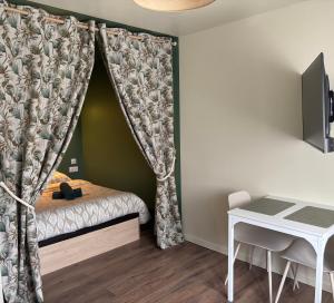 a small bedroom with a bed with a curtain at Petite pause en centre ville avec parking in Lorient
