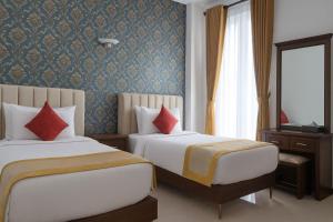 a hotel room with two beds and a television at Unique Towers Luxury Boutique Suites in Colombo