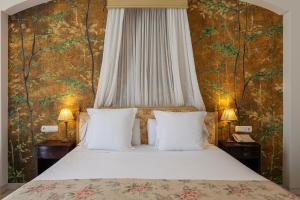a bed with two pillows in a bedroom with a wallpaper at Villa Jerez in Jerez de la Frontera +80 photos