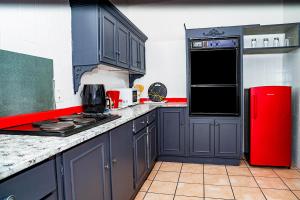 a kitchen with blue cabinets and a red refrigerator at Wakanda in Johannesburg
