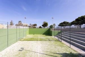 a tennis court with a green fence on a tennis court at Seafront Penthouse in El Medano in El Médano