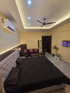 a bedroom with a large bed and a living room at Independent Homestay Near Airport in Mohali