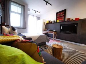a living room with two beds and a flat screen tv at Studio 207 Ebene Square Apartments in Quatre Bornes +7 photos