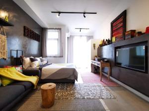 a living room with a bed and a television at Studio 207 Ebene Square Apartments in Quatre Bornes