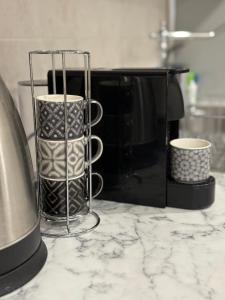 a counter with two coffee cups and a microwave at Apartment Zdravets 2, in the heart of the old city in Veliko Tŭrnovo