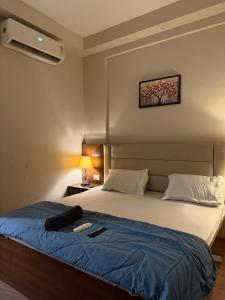 Un dormitorio con una cama con una manta azul. en Visitor stop, en Greater Noida