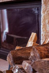 a fire place with a logs in front of it at Apartment Oganj in Jahorina