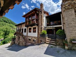 a stone house with a balcony on a mountain at Apartamentos Nevandi in Pido
