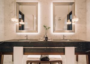 a bathroom with two sinks and two mirrors at MYTHIC SANA Downtown Suites in Lisbon