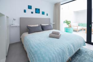 Un dormitorio con una cama grande con una manta azul. en Cascasas the Yellow Apartment, en La Oliva