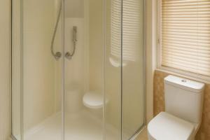 un bagno con wc e doccia in vetro di Combe Haven Holiday Park - Holiday Accommodation 12122 a Hollington