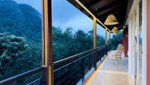 un balcon avec des chaises et une vue sur les montagnes dans l'établissement Luxury Villa in Wayanad Hills with Private Garden, à Wayanad