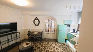 a kitchen with a table and a blue refrigerator at Moöm Apartamentos Turísticos in Tíjola