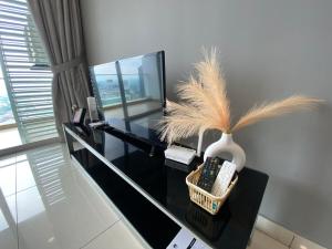 un bureau noir avec un vase et des télécommandes dessus dans l'établissement KSL D'Esplanade by ACJB HomeStay, à Johor Bahru 8 autres photos