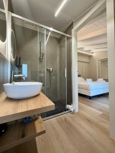 a bathroom with a sink and a glass shower at LE Home Soave - Locazione Turistica in Soave