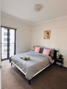 a bedroom with a large bed and a large window at Minimalist 2-Bed, 2-Bath Apartment in Melbourne CBD - Free Parking in Melbourne