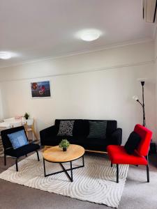 a living room with a couch and two chairs and a table at Minimalist 2-Bed, 2-Bath Apartment in Melbourne CBD - Free Parking in Melbourne