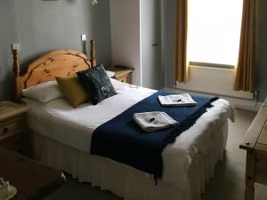 a bedroom with a bed with two towels on it at The George Hotel in Newent +3 photos